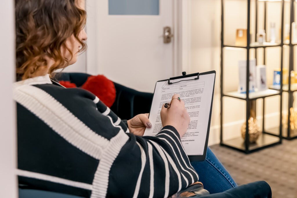 A patient fills out an intake form at Vital Balance 10, where she will receive muscle recovery solutions.